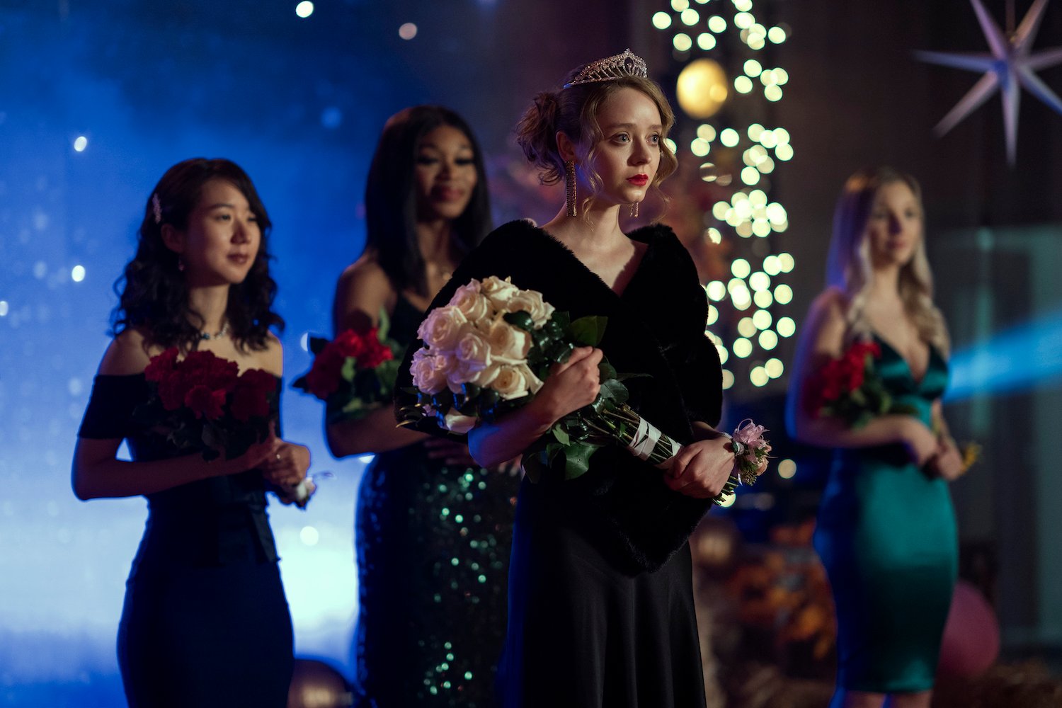 Madeleine Arthur wearing a black dress and holding white roses in a production still from 'Devil in Ohio'