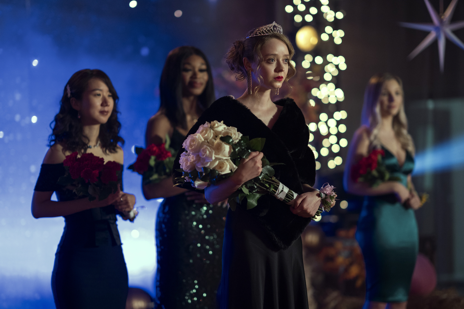 Madeleine Arthur wearing a black dress and holding white roses in a production still from 'Devil in Ohio'