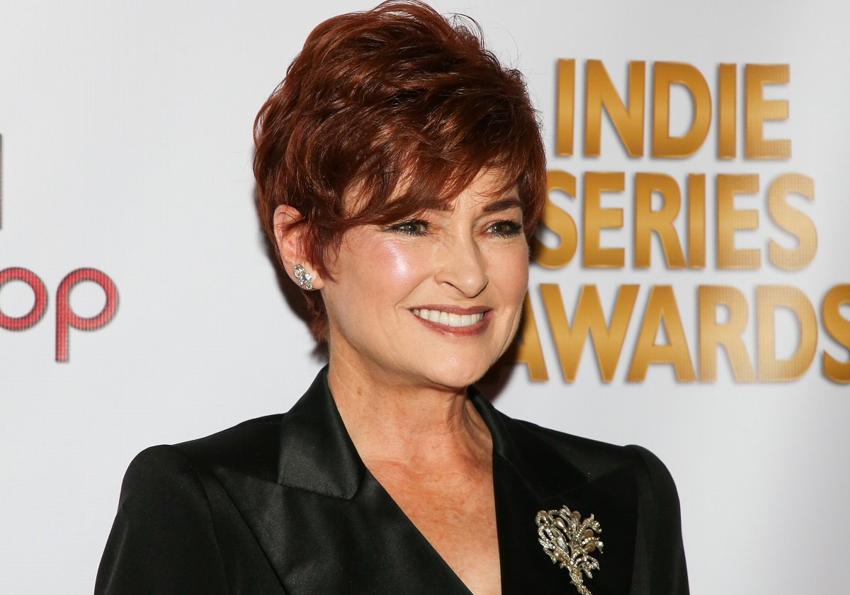 'General Hospital' star Carolyn Hennesy wearing a black suit and smiling for photographers.