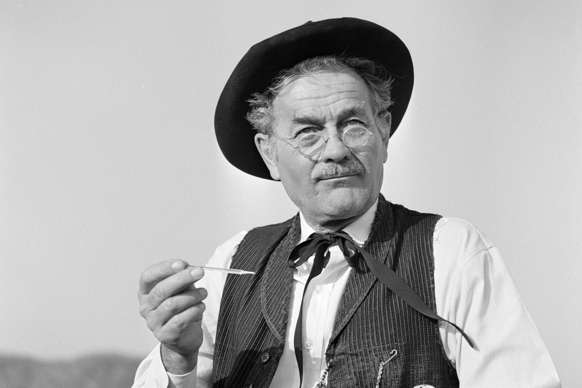 'Gunsmoke' Milburn Stone as Doc Adams wearing Western clothing holding a syringe and wearing glasses