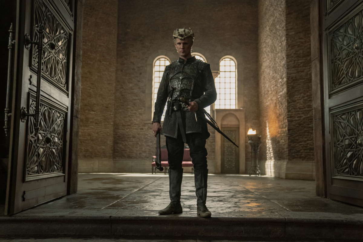 Matt Smith as Demon Targaryen in House of Dragons.  Satan wears a shield and a crown and has a sword at his side. 