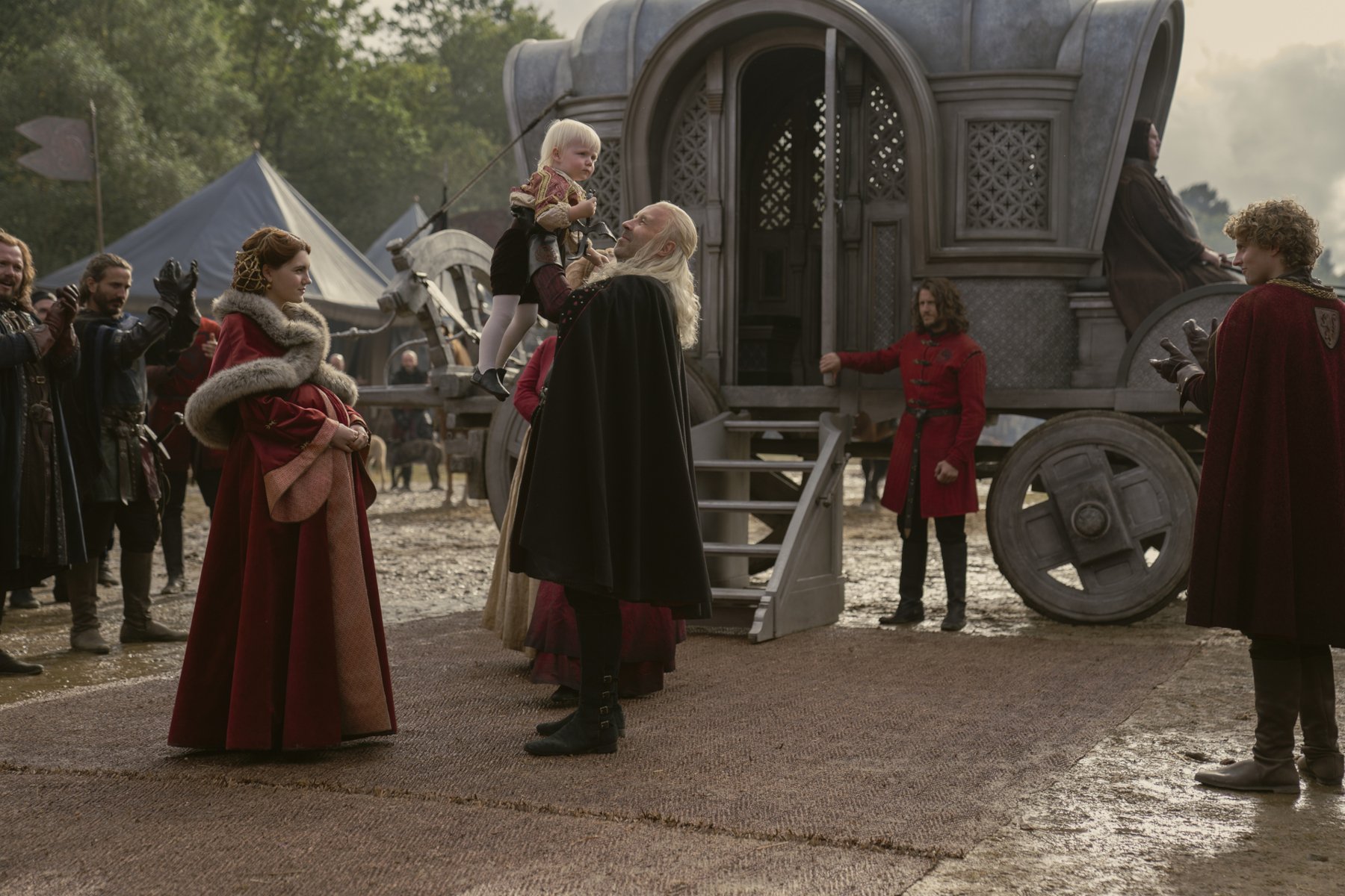 Emily Carey as Alicent Hightower and Paddy Considine as King Viserys. They're standing outside of a carriage and Viserys is holding up their child. His son may present a problem for Rhaenyra heading into 'House of the Dragon' Episode 4.