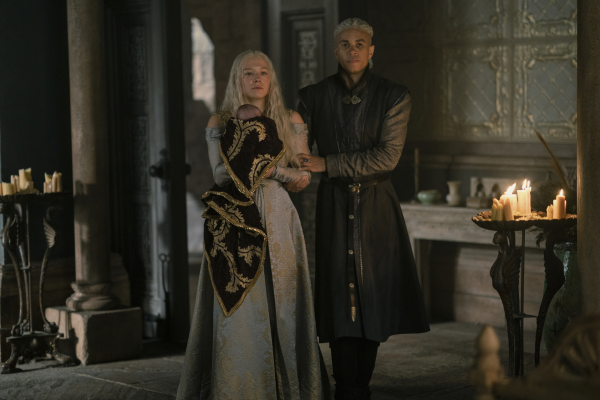 The House of the Dragon Episode 6 preview depicts rumors about the fatherhood of Rhaenyra's children. In this photo Rhaenyra holds her baby and stands next to Laenor.