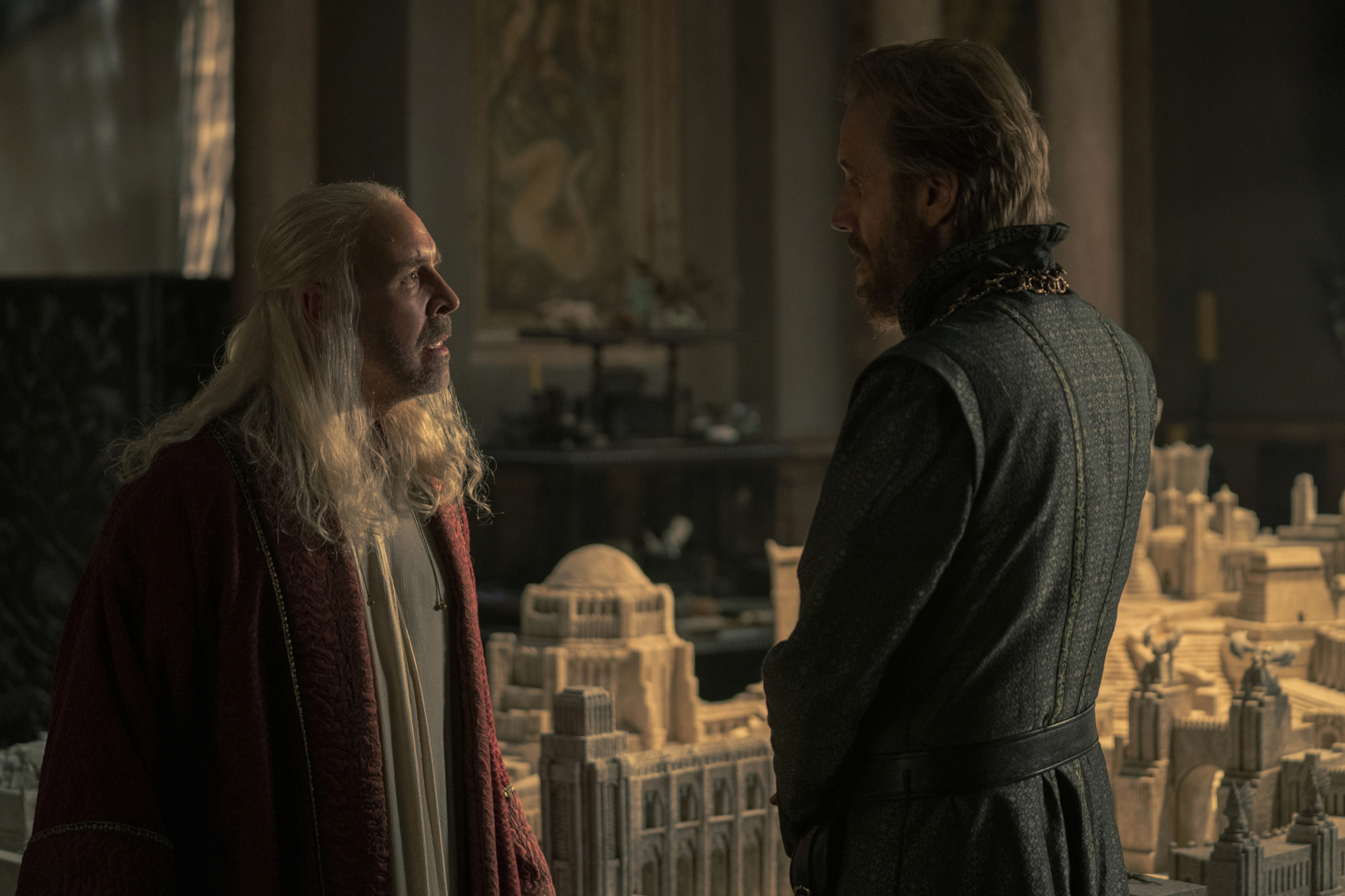 Paddy Considine and Rhys Ifans as King Viserys and Otto Hightower in 'House of the Dragon' Episode 4. They're facing one another, and Viserys looks angry.