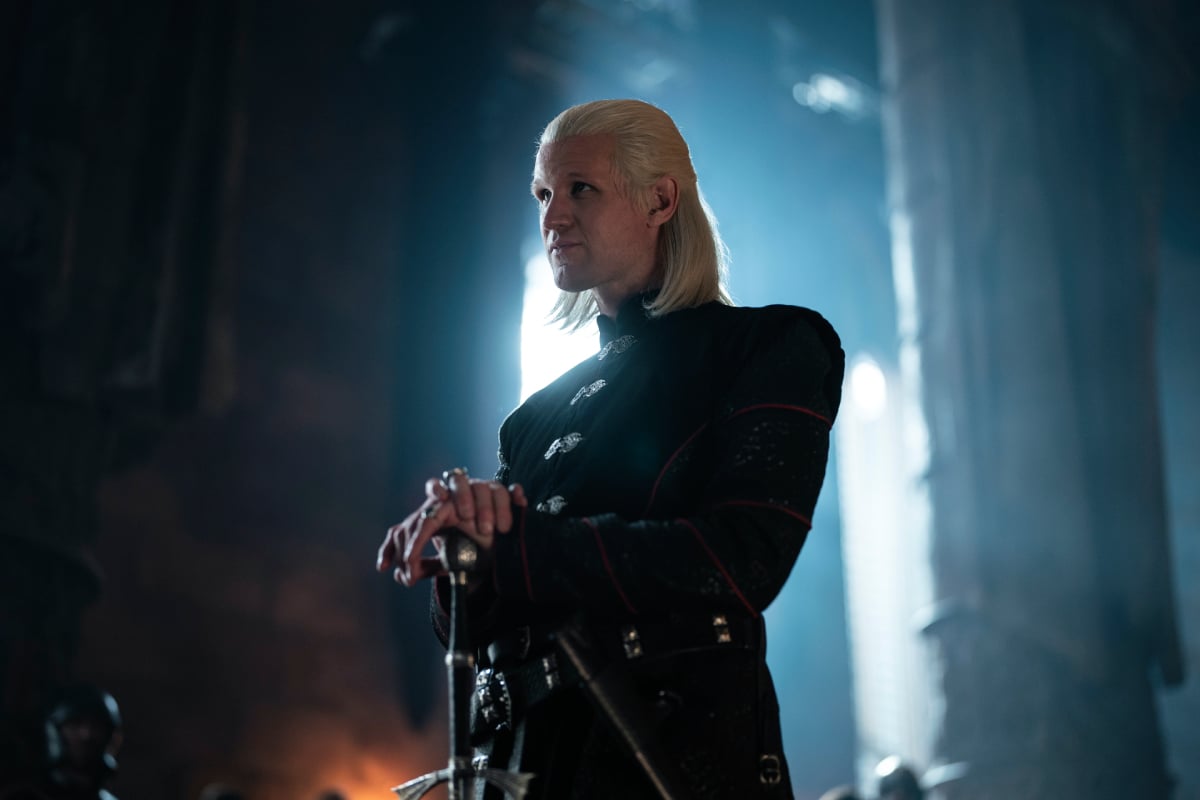Matt Smith wears a blonde wig as Daemon in House of the Dragon. He also leans on a sword in front of him. 