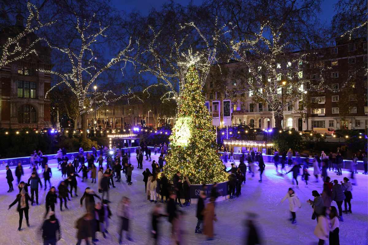People ice skating around a Christmas tree in London