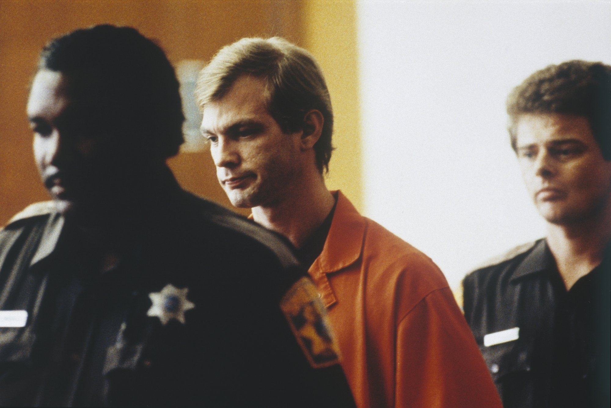 Jeffrey Dahmer, who committed 17 killings. He's wearing an orange jumpsuit while he's being escorted by court security.