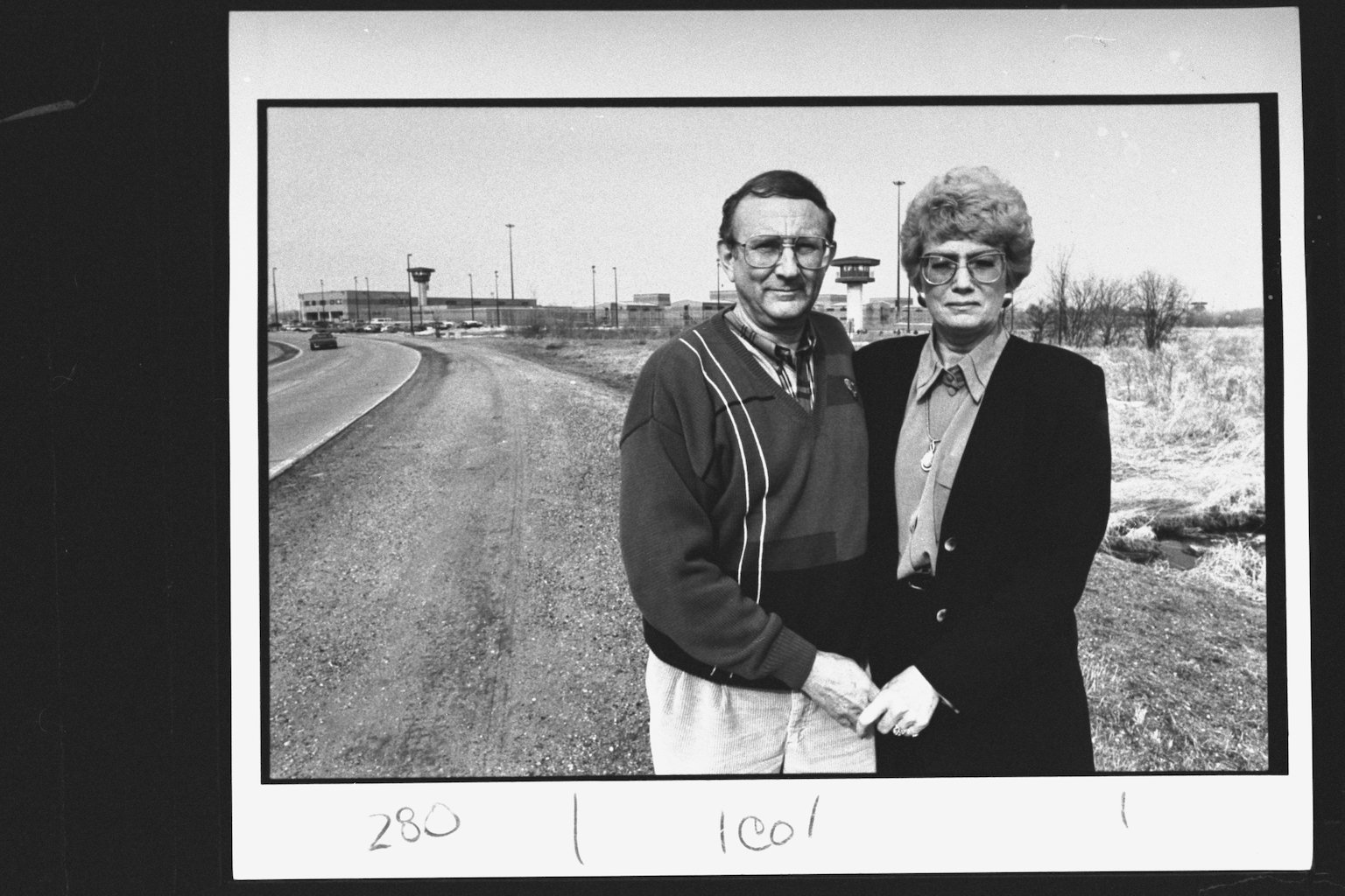 A black and white photo of Jeffrey Dahmer's father, Lion Dahmer, holding hands with his wife, Shari Dahmer