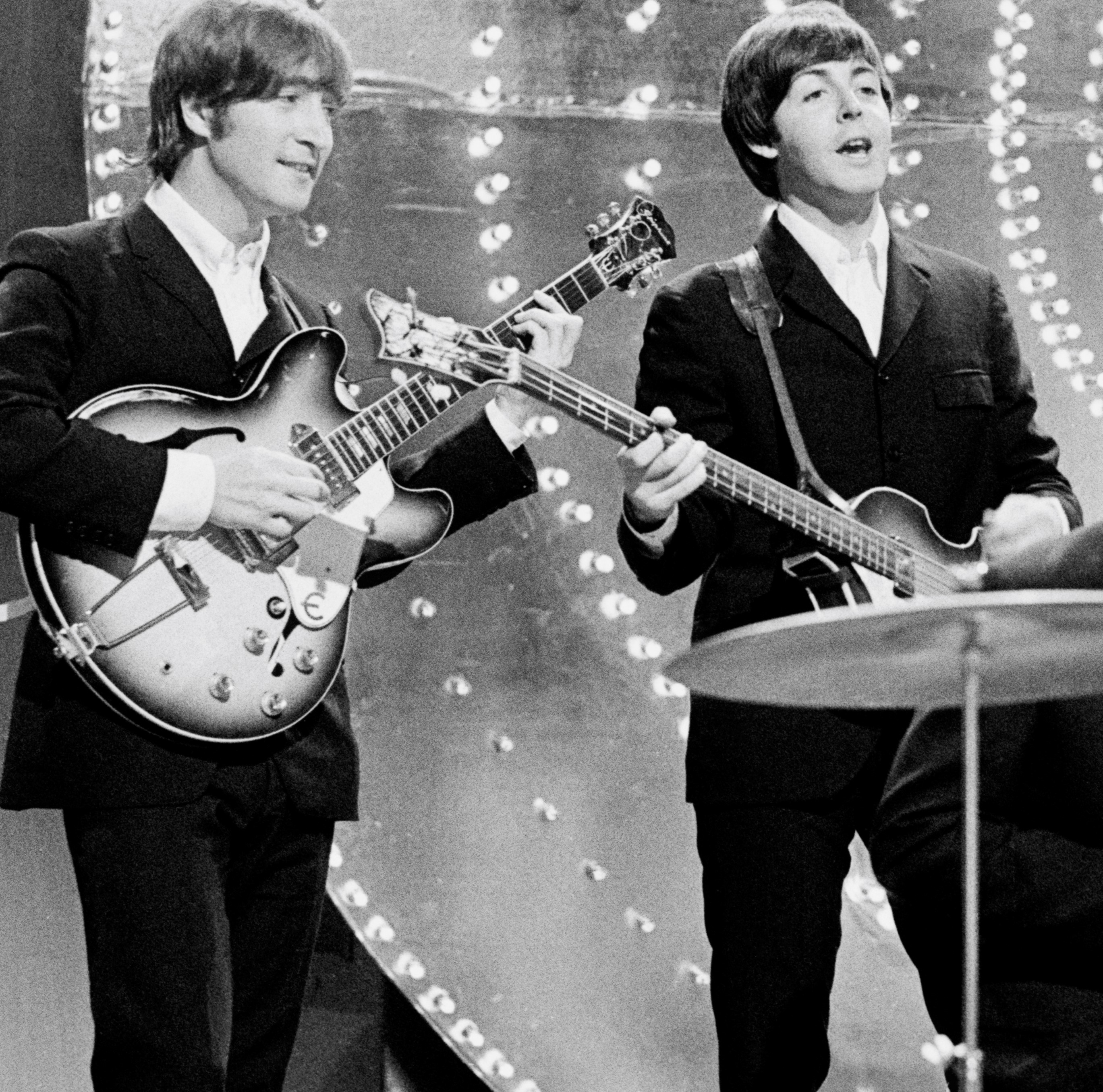 John Lennon and Paul McCartney playing The Beatles' songs on guitars