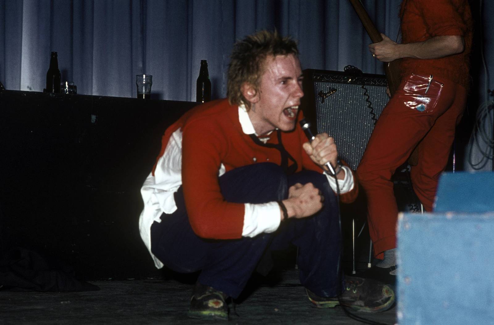 Sex Pistols frontman John Lydon crouches during a performance, which often included 'God Save the Queen'