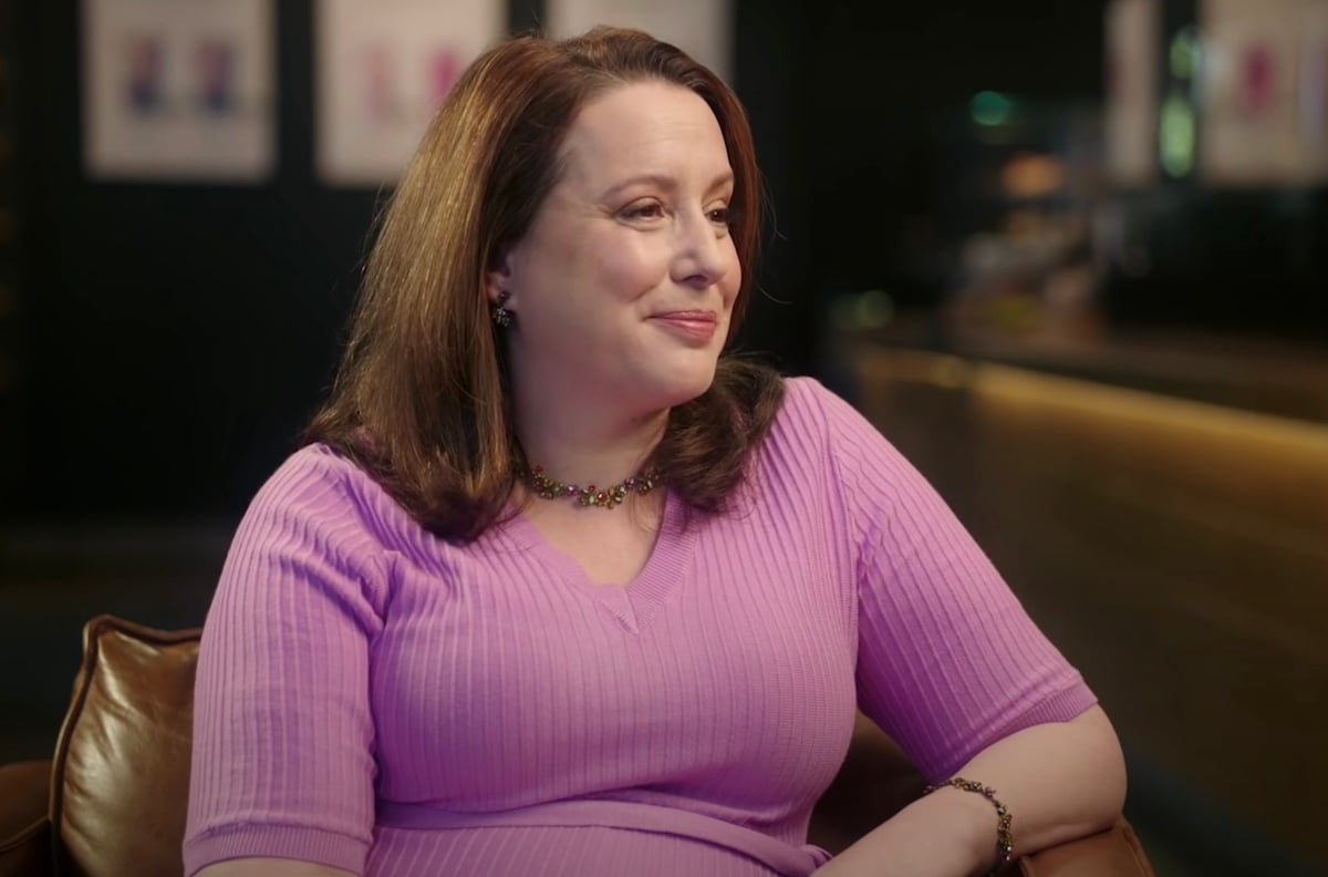 Julia Quinn is interviewed about Bridgerton while wearing a pink top