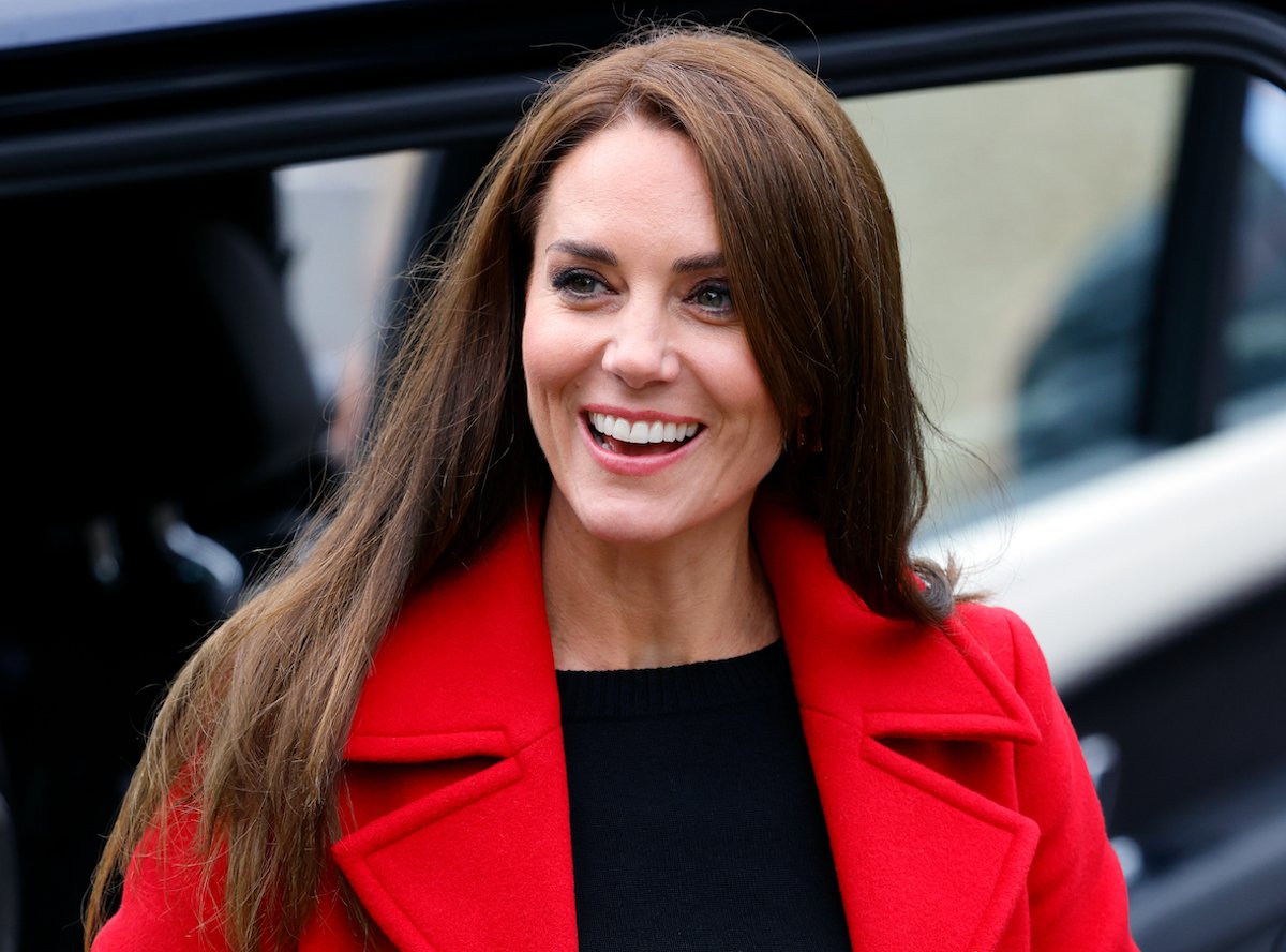 Kate Middleton, who according to body language expert Judi James, demonstrated a child had her 'total attention' during a Sept. 27 appearance in Wales by not being concerned when her red coat touched the ground as they talked, smiles and looks on in Wales
