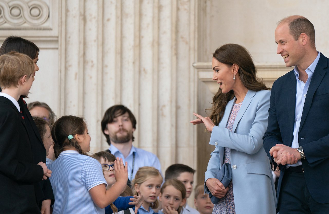 Kate Middleton, pictured with Prince William and school children in 2022, received a job offer from a daycare for her 'natural' way with kids.