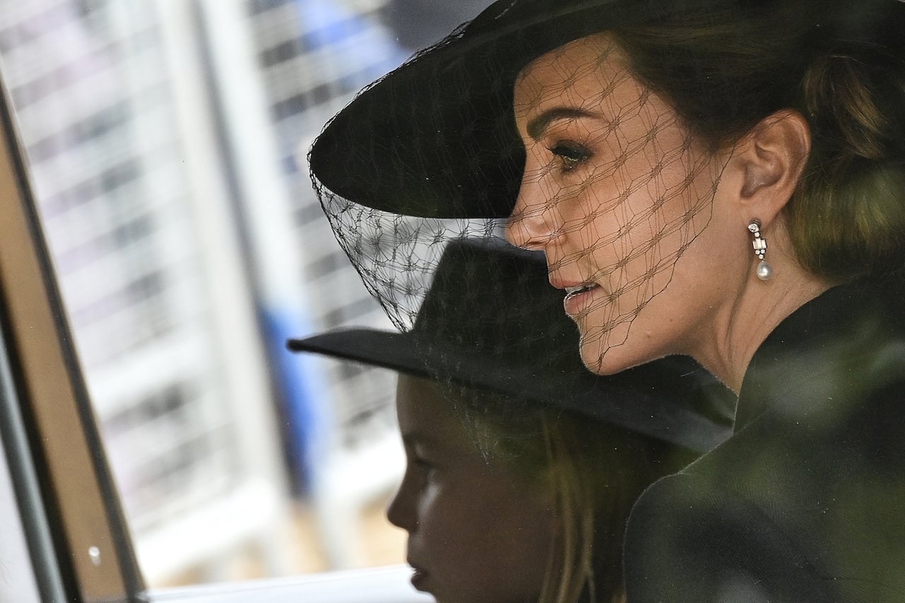 Kate Middleton, Princess of Wales, and Princess Charlotte of Wales driving behind the procession of the coffin towards Buckingham Palace following the State Funeral of Queen Elizabeth II at Westminster Abbey on September 19, 2022, in London, England. Kate Middleton's funeral accessory honored Queen Elizabeth and Princess Diana.