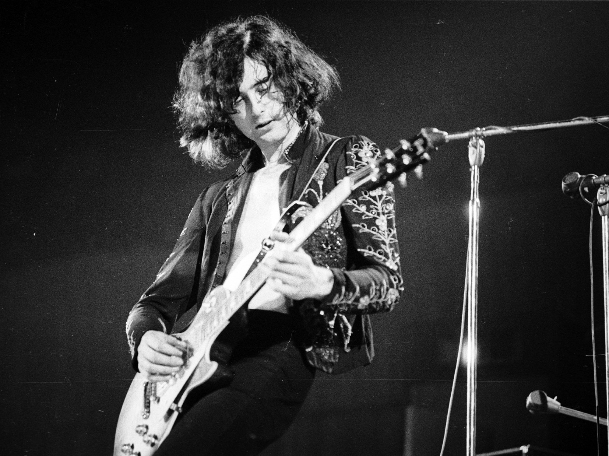 A black-and-white photo of Jimmy Page playing the guitar
