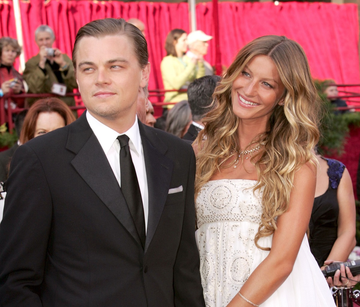 Leonardo DiCaprio and Gisele Bundchen smiling on the red carpet at the 77th Annual Academy Awards