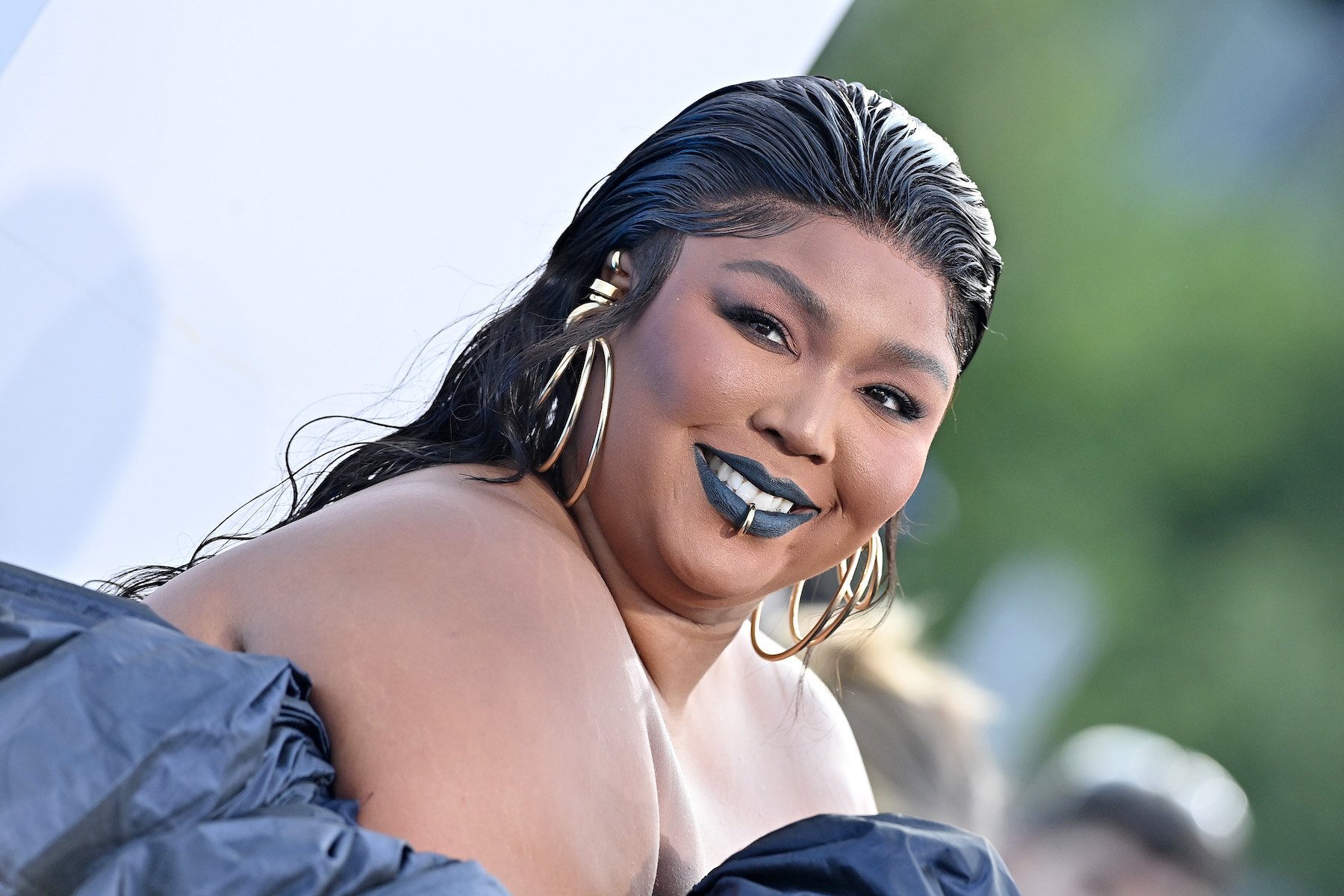 Lizzo, who played James Madison's crystal flute, wearing blue with slicked back hair.
