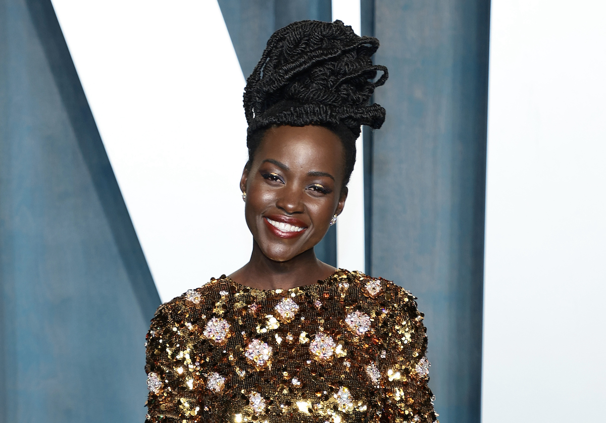 In a gold sequined dress, Lupita Nyong'o smiles at the 2022 Vanity Fair Oscar Party