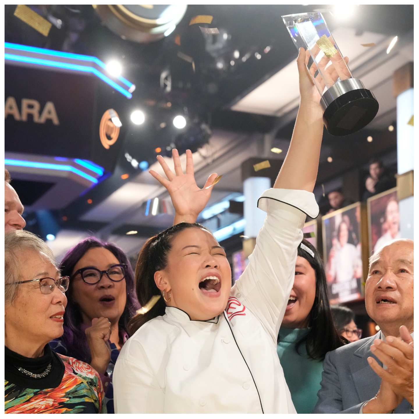 Dara Yu won 'MasterChef: Back to Win' and proudly holds the trophy over her head while surrounded by her family