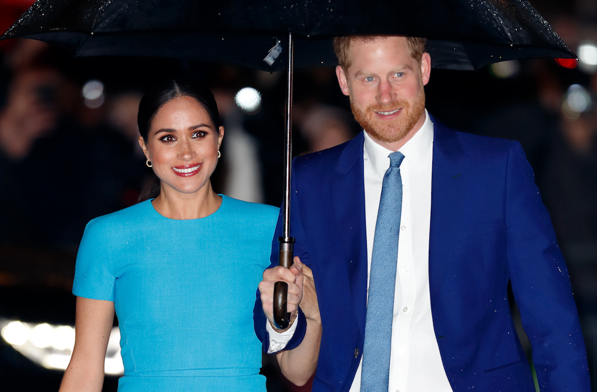 Meghan Markle, who said she and Prince Harry knew they wanted their Montecito mansion after only seeing the grounds, walks with Prince Harry under an umbrella
