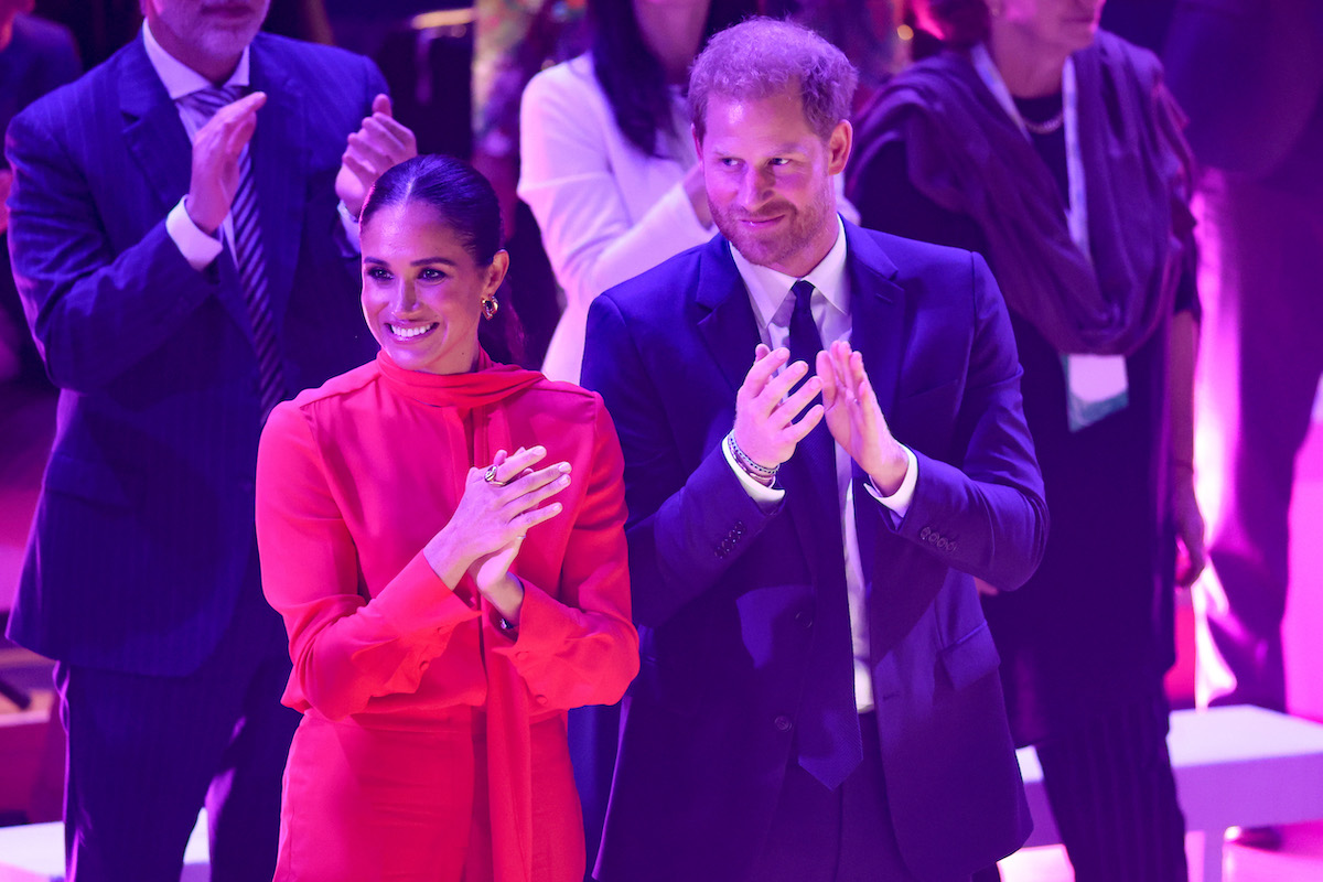 Meghan Markle and Prince Harry, whose body language Darren Stanton analyzed, clap at the 2022 One Young World Summit opening ceremony