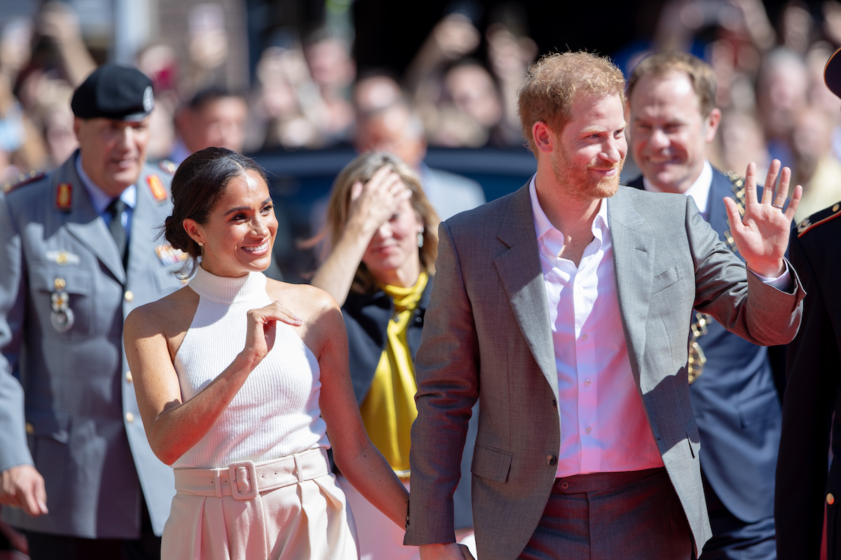 Meghan Markle and Prince Harry in Germany during their U.K. return which, according to Omid Scobie, a source said Meghan Markle and Prince Harry 'never reached out' to Prince William and Kate Middleton ahead of their U.K. return