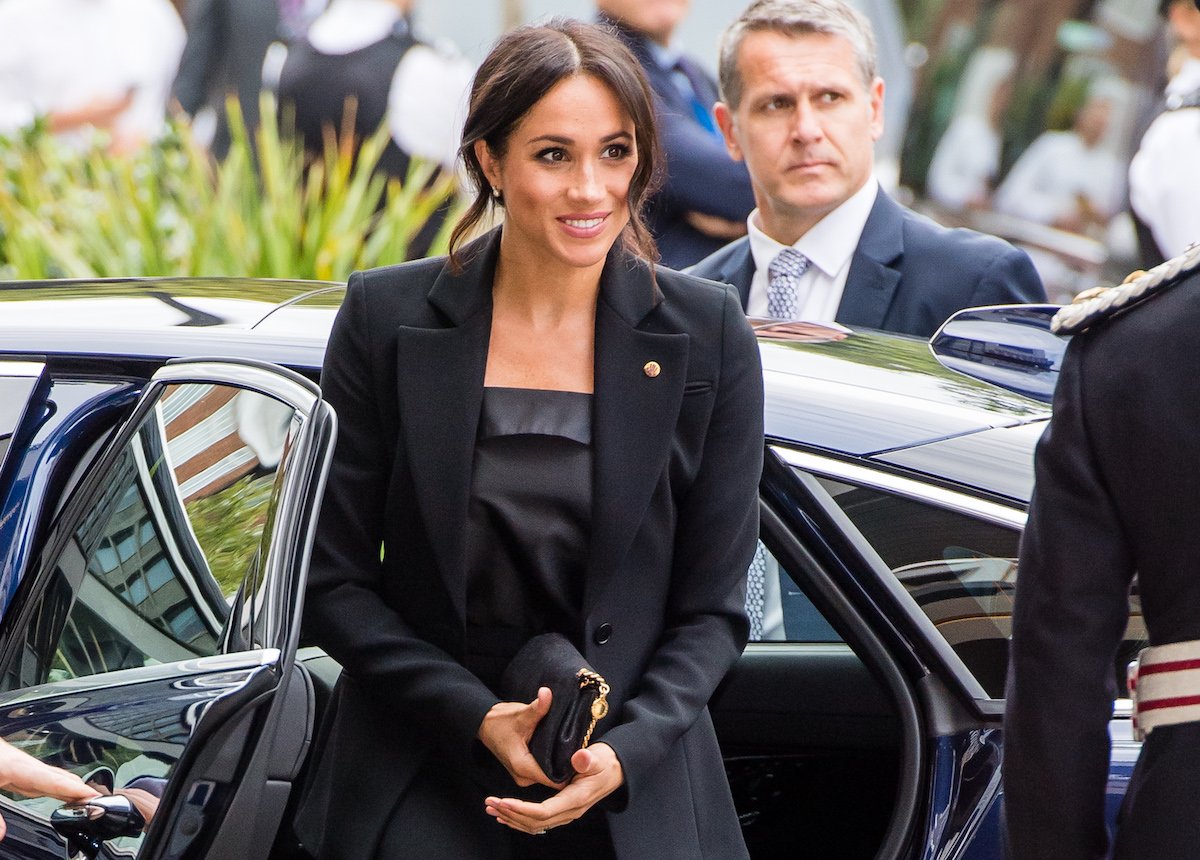 Meghan Markle, who did a 'canny move' by putting her arm on Prince Harry's lower back at the 2018 WellChild Awards according to a body language expert, steps out of a car as she arrives at the 2018 WellChild Awards