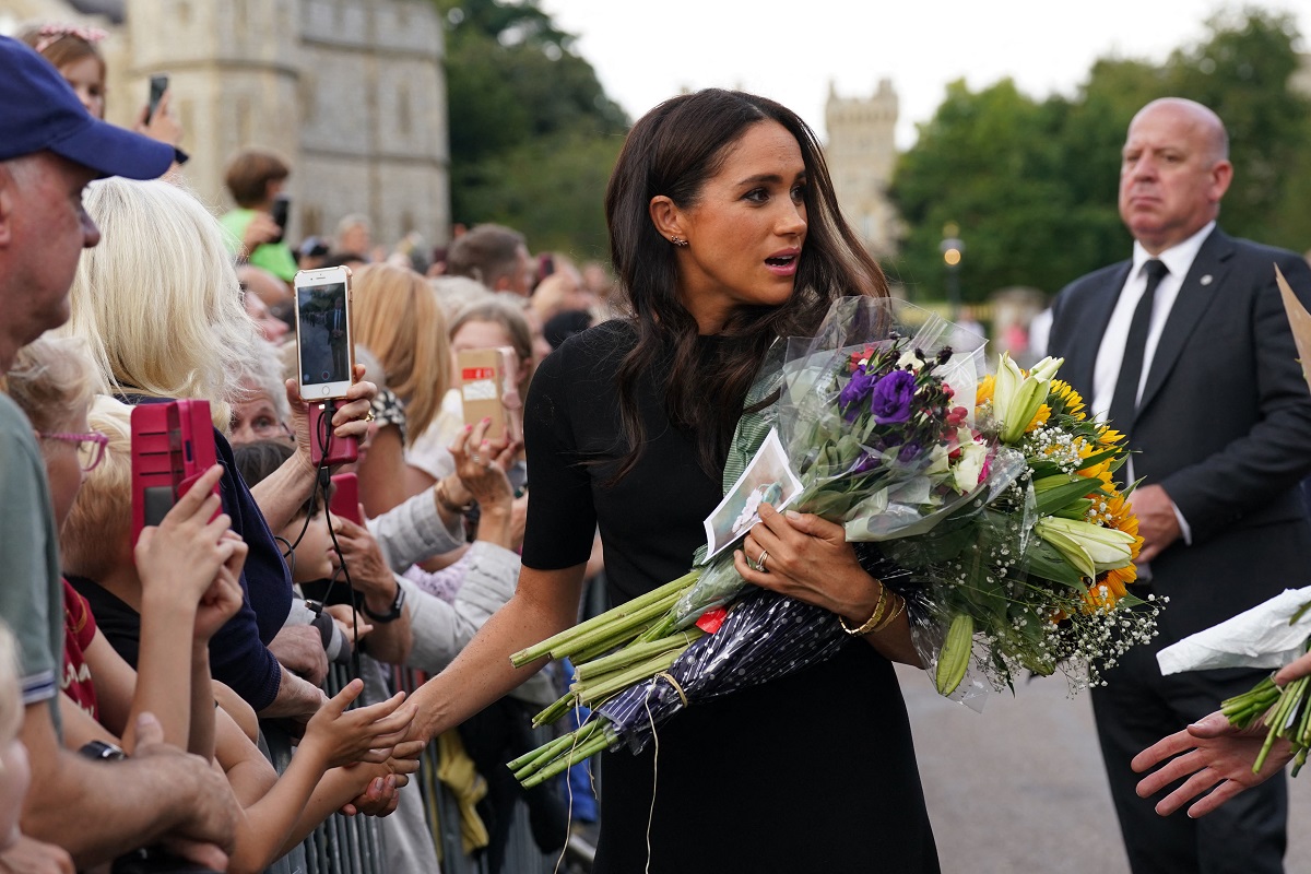 Meghan Markle holding flowers and greeting well-wishers on the Long Walk at Windsor Castle