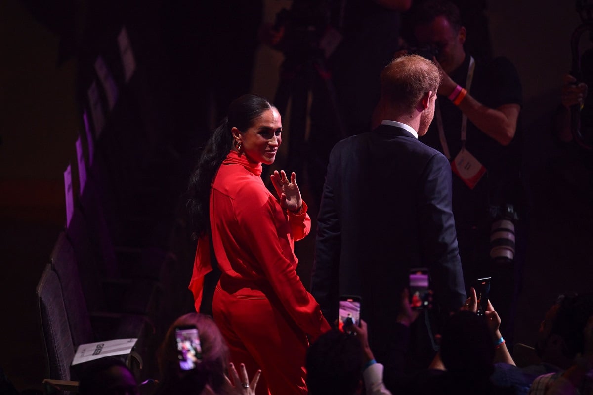 Meghan Markle waves to the audience as she and Prince Harry attend the annual One Young World Summit