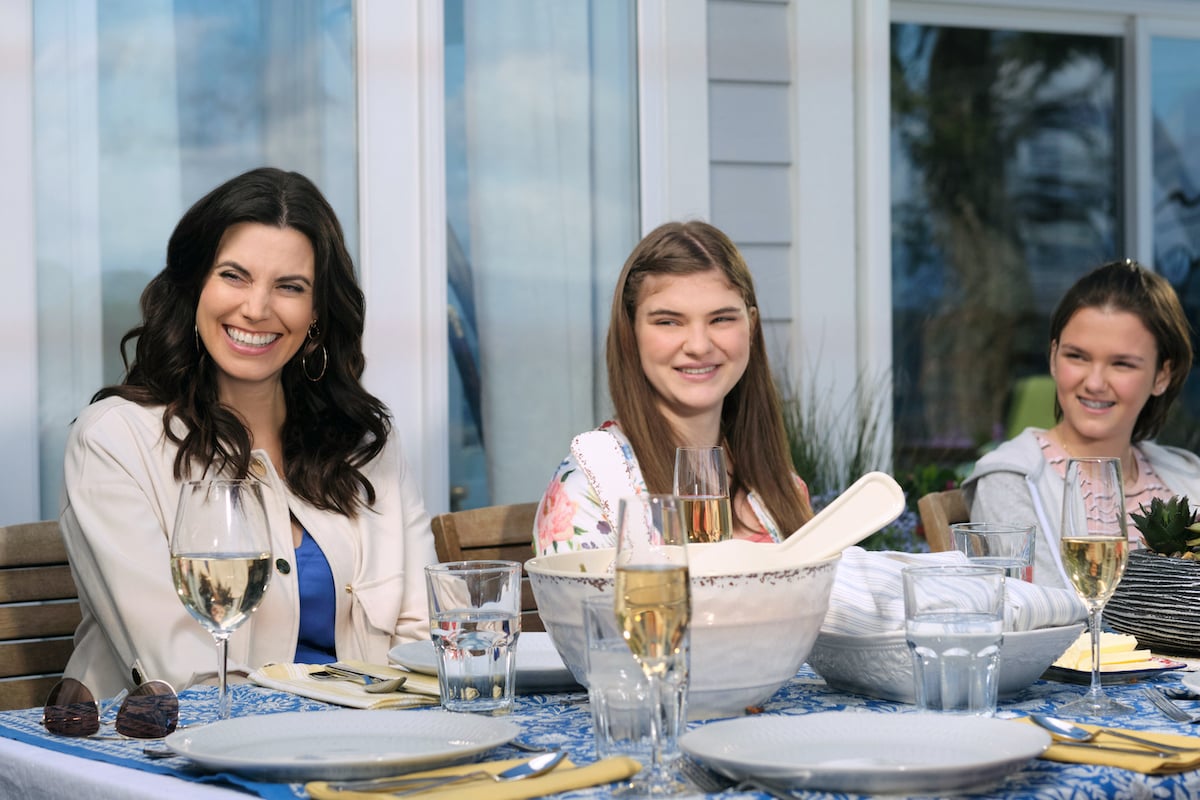 Abby sitting at a table with her two daughters in 'Chesapeake Shores' Season 6