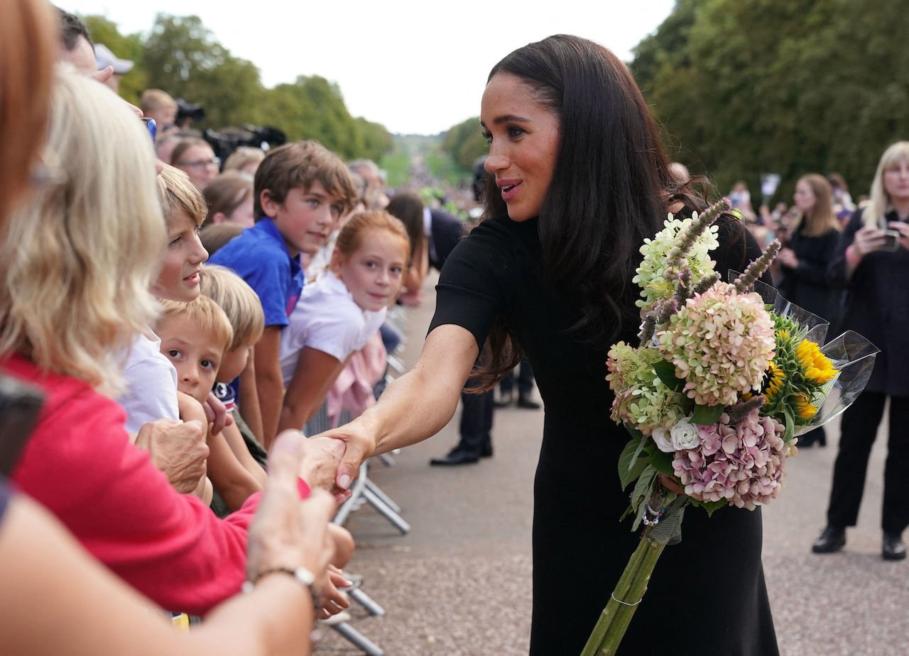 Meghan Markle, picture talking with well-wishers at Windsor Castle, held tight to flowers for the queen.