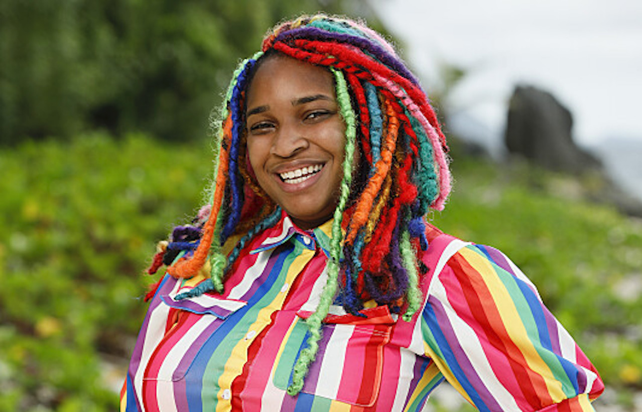 Morriah Young poses on the beach in a rainbow striped dress for 'Survivor 43'.