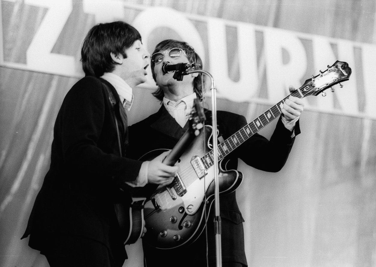 Paul McCartney (left), who needed to see a photo to remember he wasn't the villain of the Beatles' break-up, and John Lennon share the microphone during a 1966 Beatles concert.