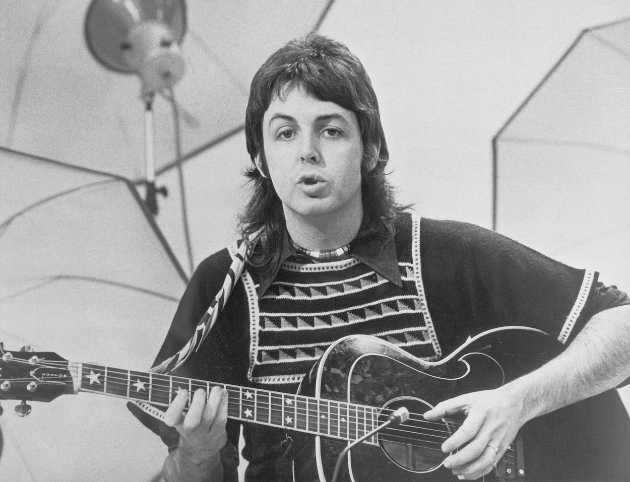 Paul McCartney plays guitar while filming a 1973 TV special. McCartney once wrote a song about Picasso's last words when a famous actor urged him to, and it ended up on a hit album.