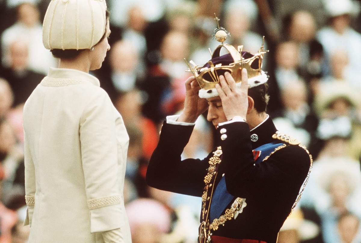 Prince Charles kneels before Queen Elizabeth II as she crowns him Prince of Wales during the Investiture at Caernarvon Castle