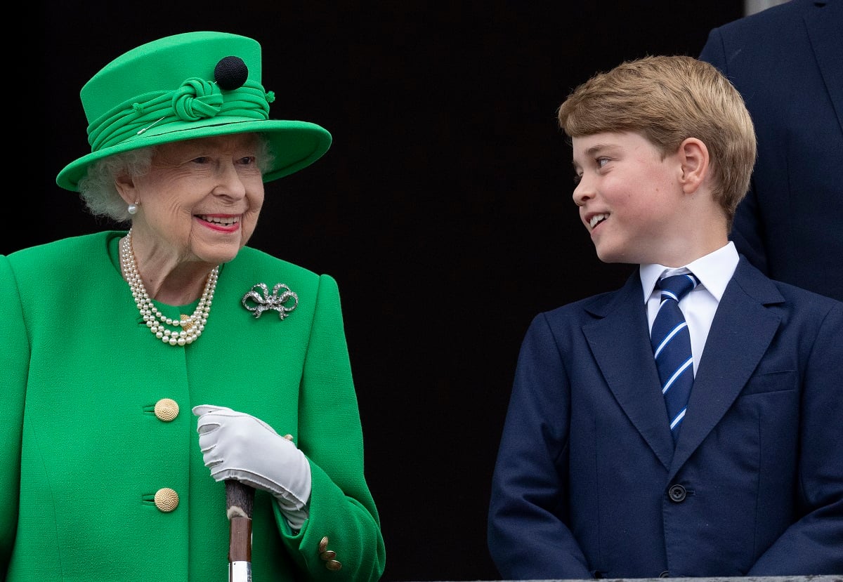 Prince George looking at his great-grandmother, Queen Elizabeth II, as they stand on the balcony of Buckingham Palace