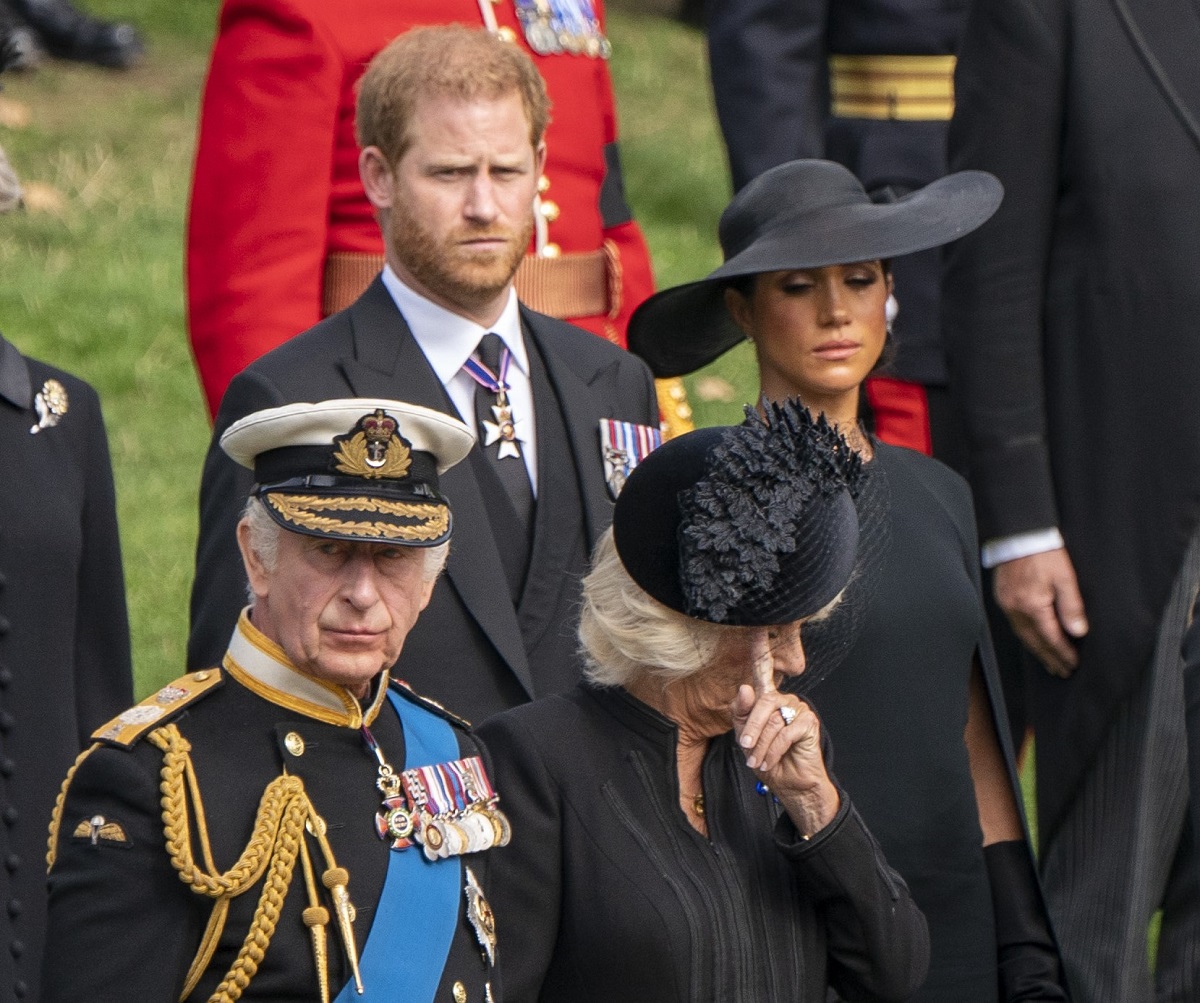 Prince Harry, Meghan Markle, King Charles III, and Camilla Parker Bowles watching the State Gun Carriage carrying the coffin of Queen Elizabeth II