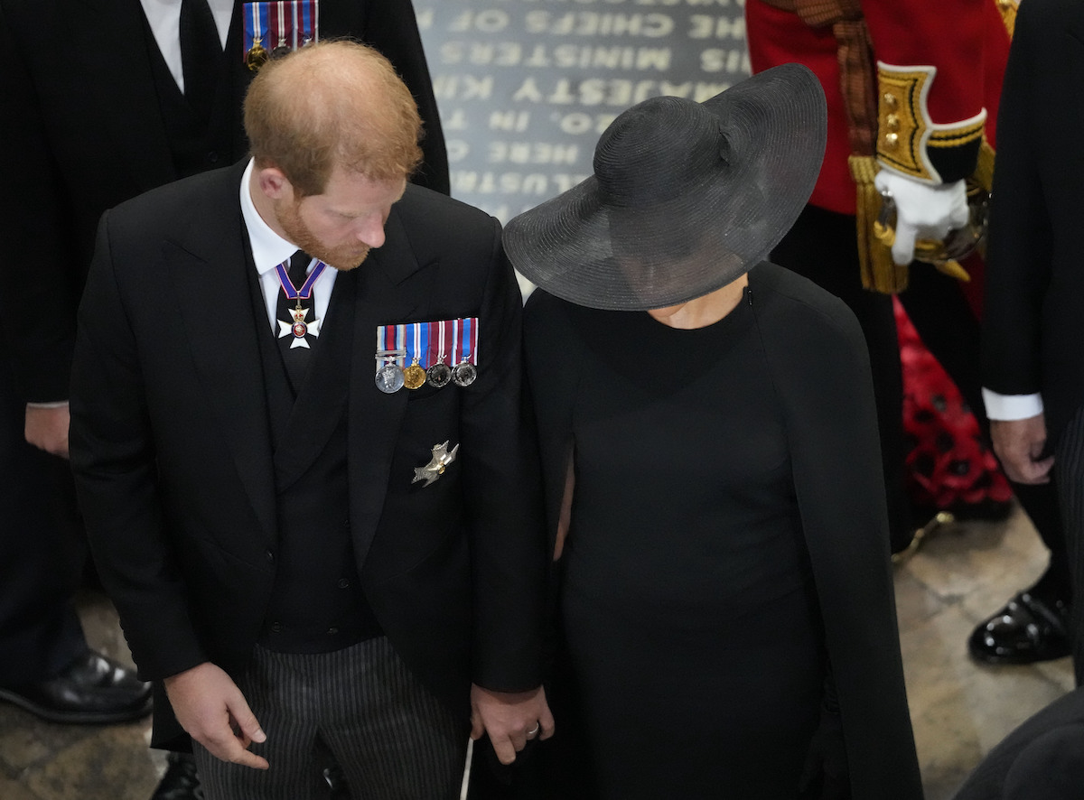 Prince Harry, who had a particularly difficult time at Queen Elizabeth's funeral as the coffin was moved, according to a body language expert, exits Queen Elizabeth's funeral with Meghan Markle