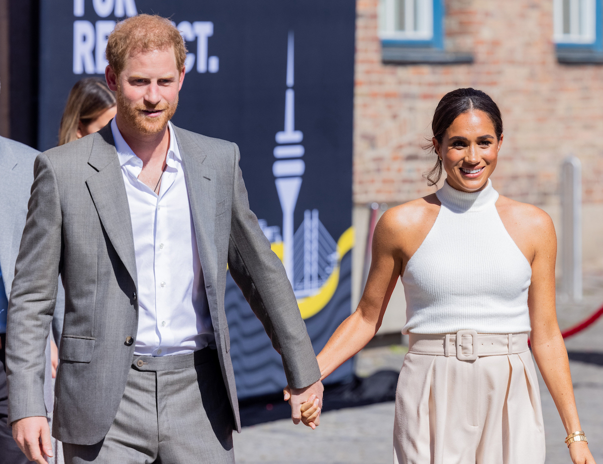 Prince Harry and Meghan Markle, who were gifted Frogmore Cottage by Queen Elizabeth, hold hands during a September 2022 visit to Germany