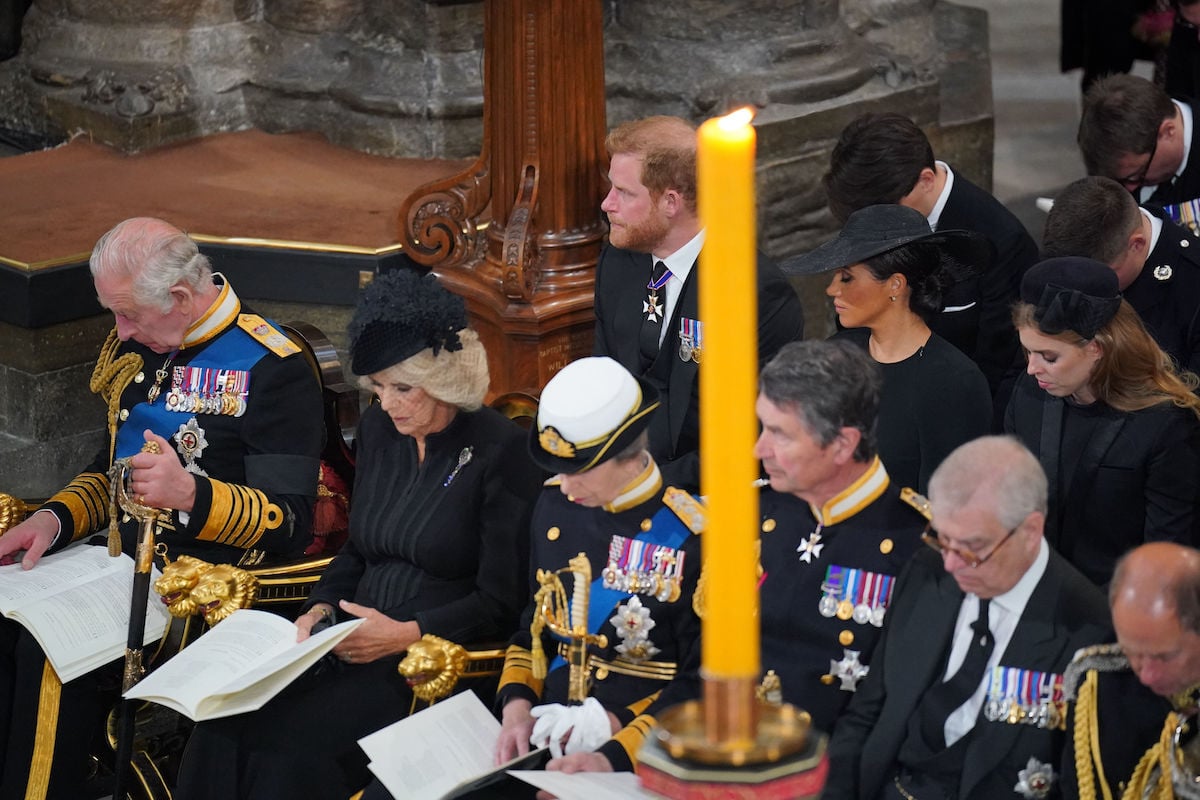 Prince Harry and Meghan Markle, who sat in the second row at Queen Elizabeth's funeral reportedly due to age order seating arrangements, sit at Westminster Abbey with the royal family