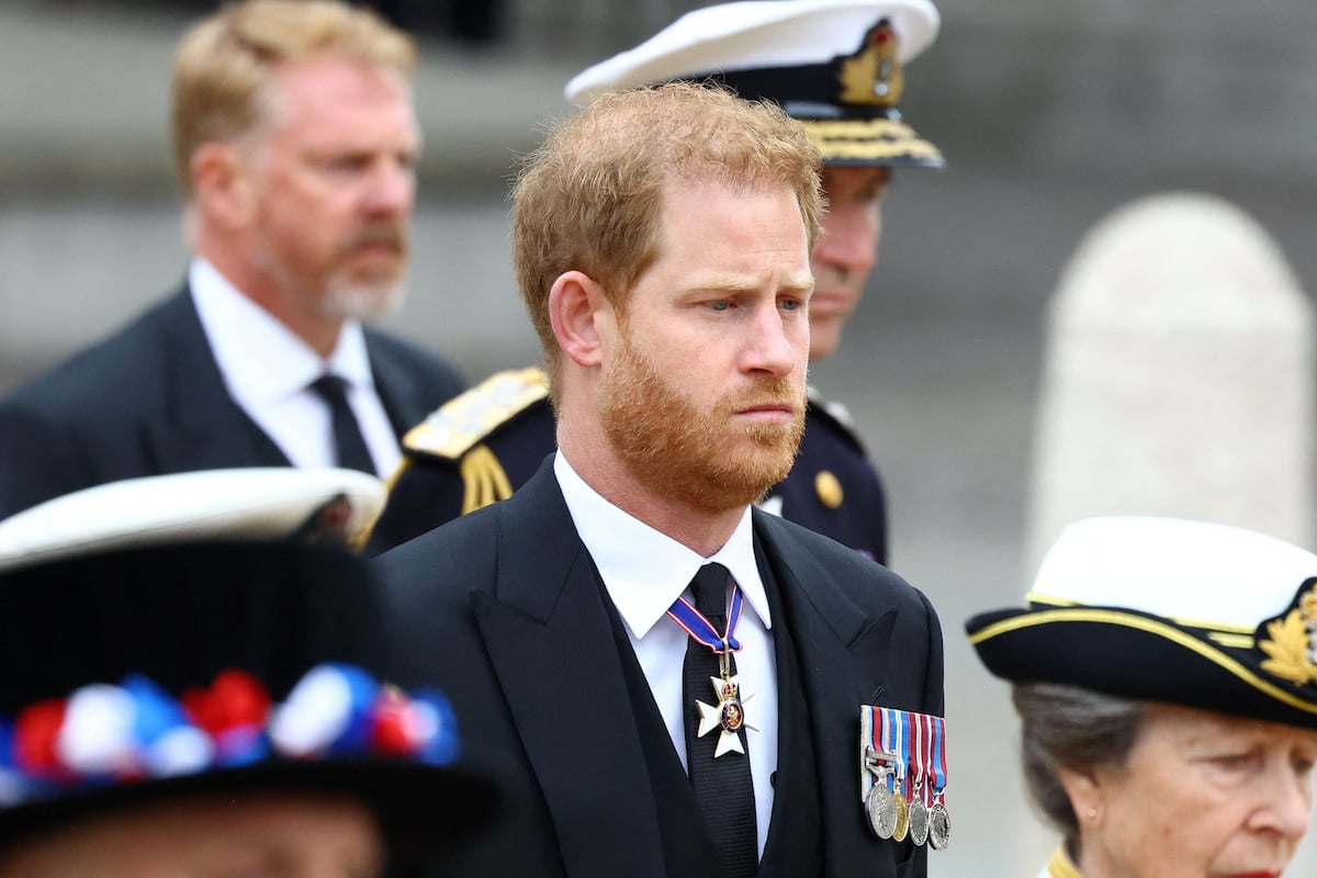 Prince Harry, who may or may not have been singing the national anthem at Queen Elizabeth's funeral, walks outside Westminster Abbey