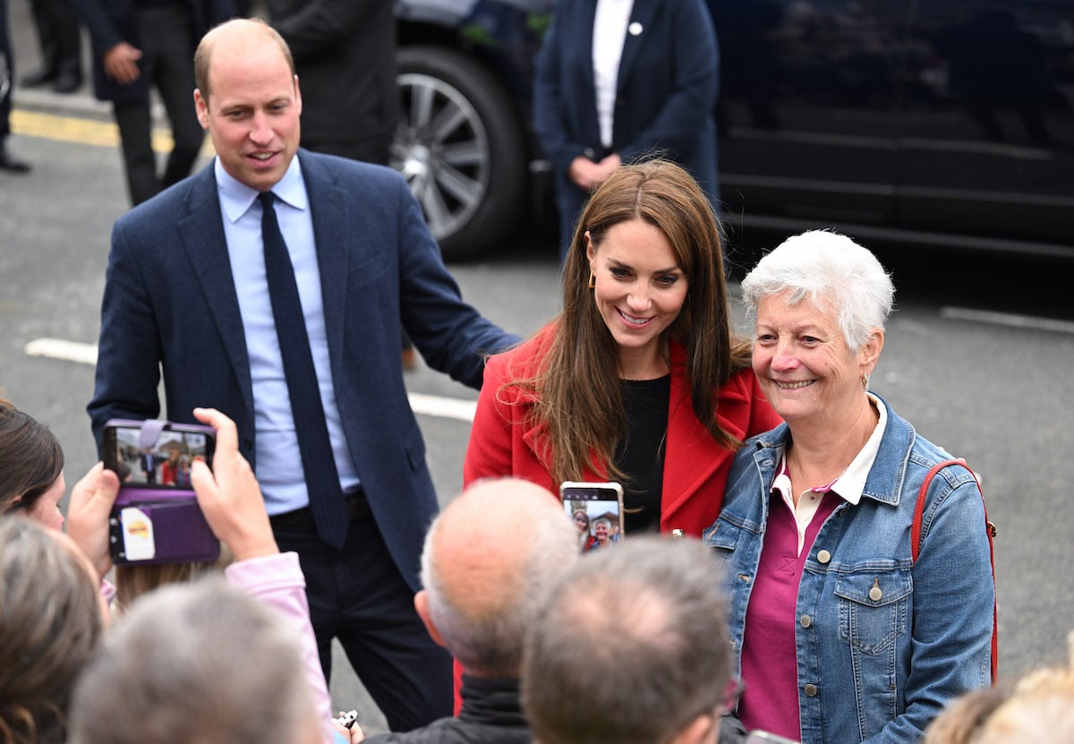 Prince William looks on as Kate Middleton poses for a photo in Wales on Sept. 27, 2022