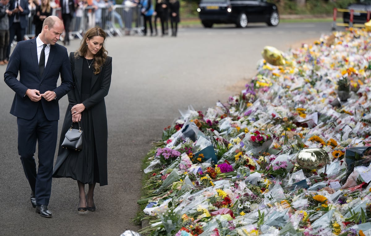 Prince William and Kate Middleton, whose body language an expert broke down after they visited Sandringham on Sept. 15, 2022, to see  Queen Elizabeth tributes, look at flowers