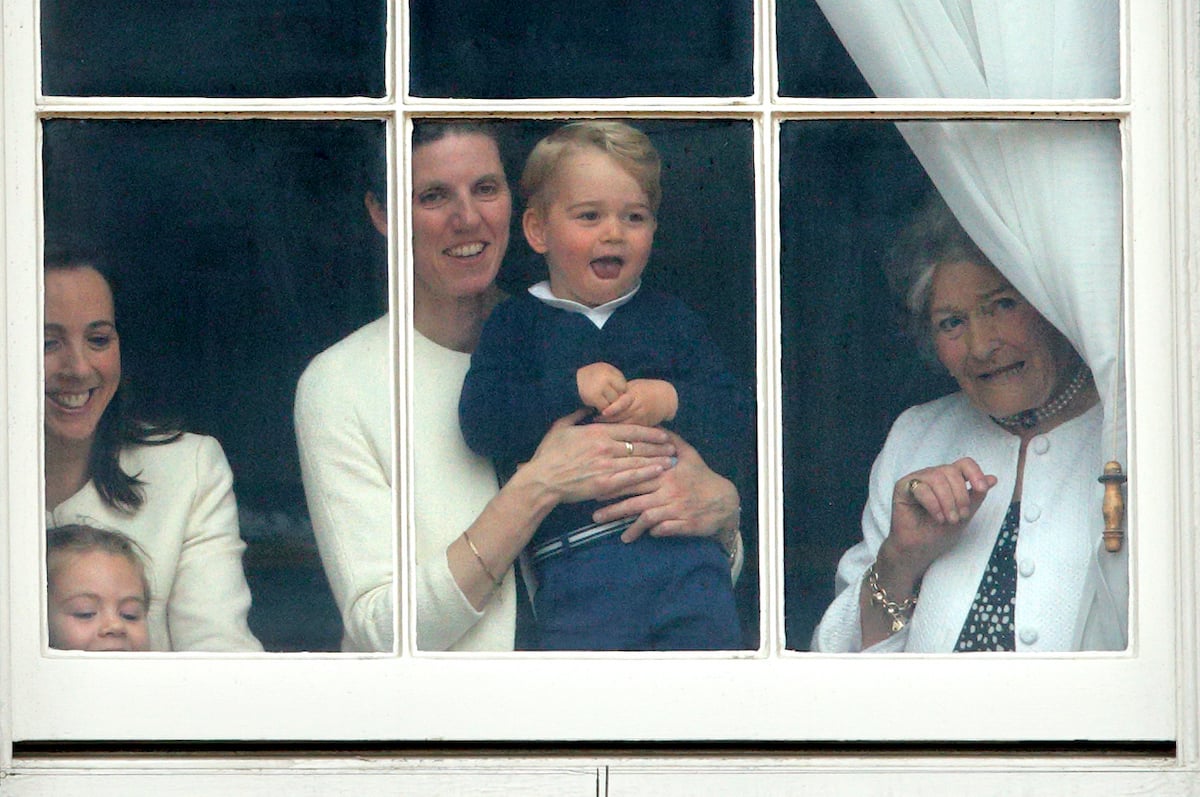 Maria Borrallo, nanny to Prince William and Kate Middleton's children, holds Prince George as they watch Trooping the Colour through a window in 2015