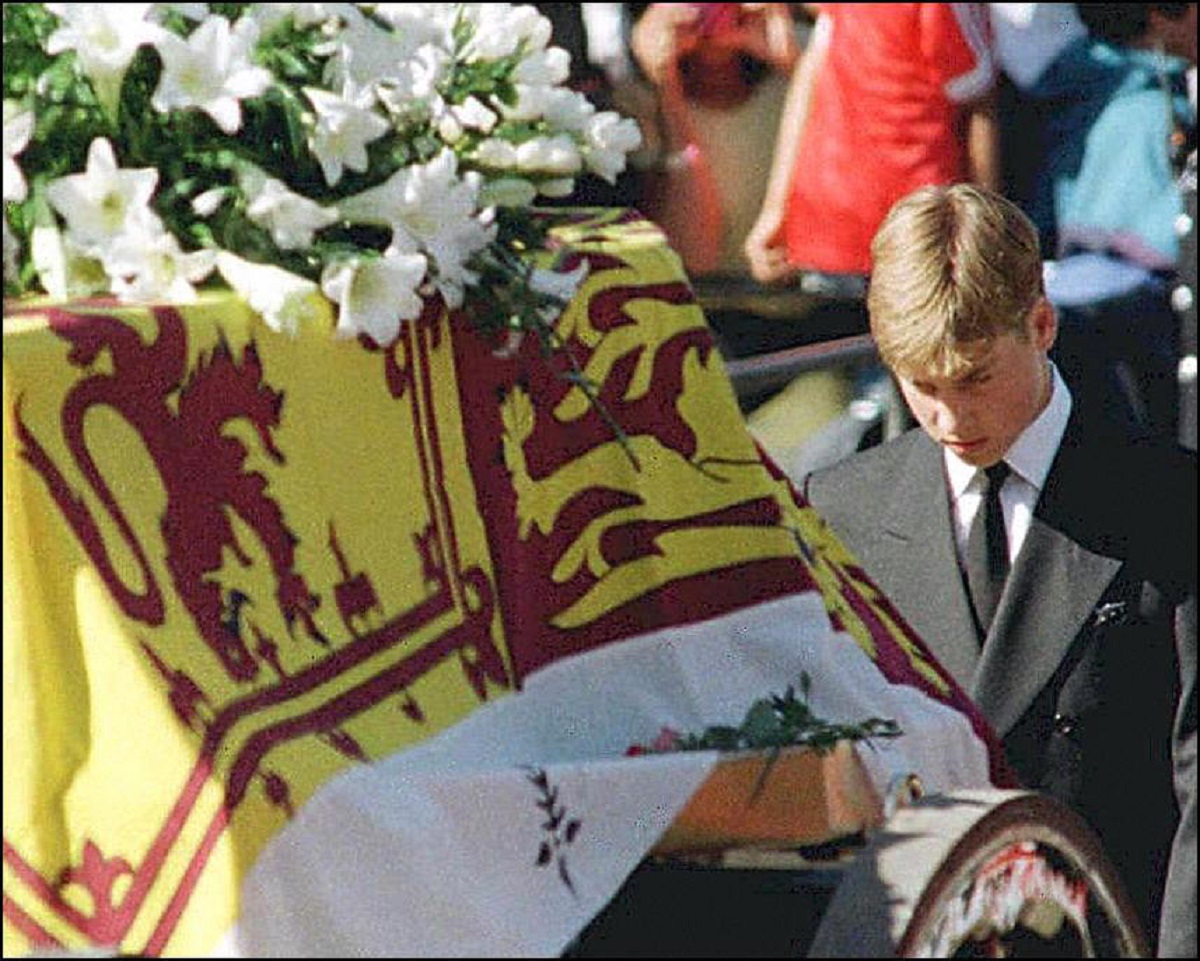 Prince William walks with his head bowed behind the coffin of his mother 