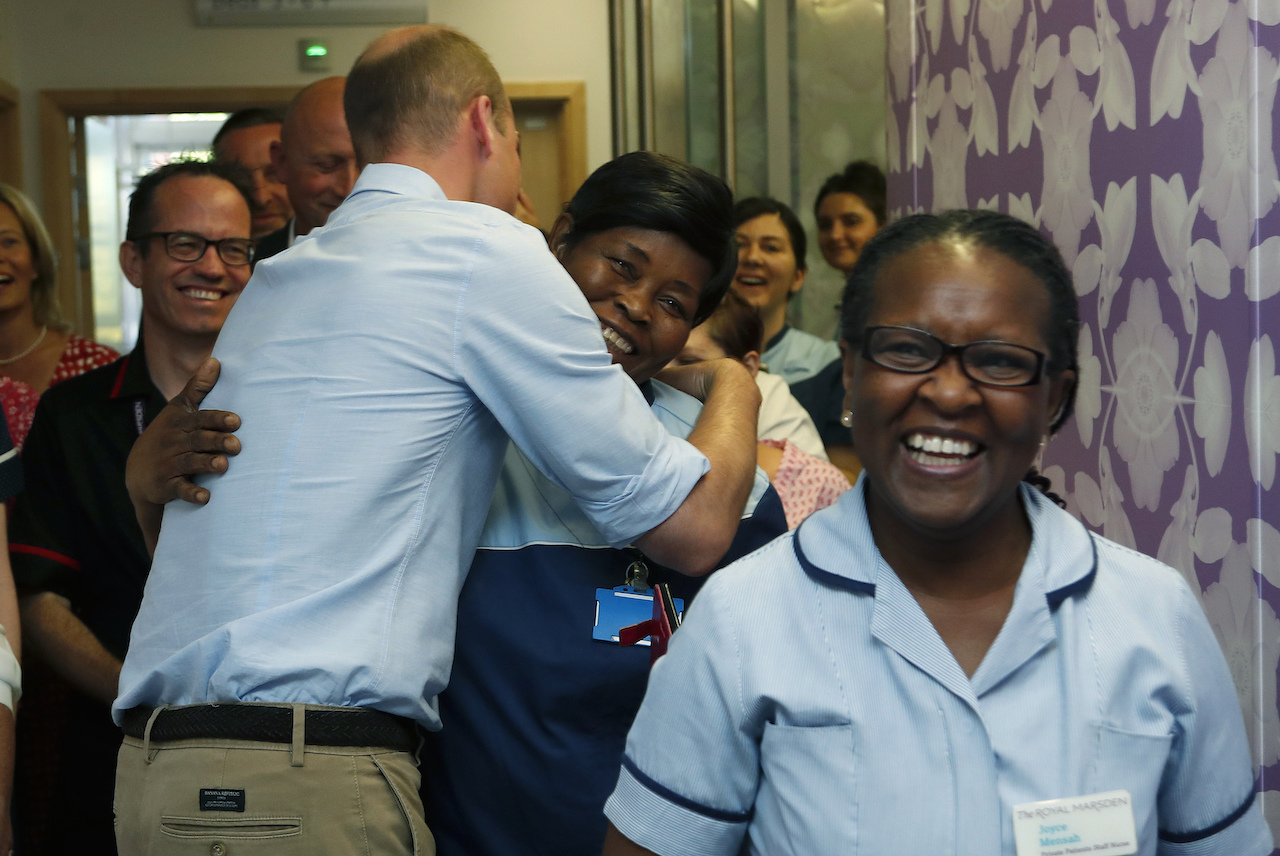 Prince William hugs a cleaner as he visits The Royal Marsden in 2019