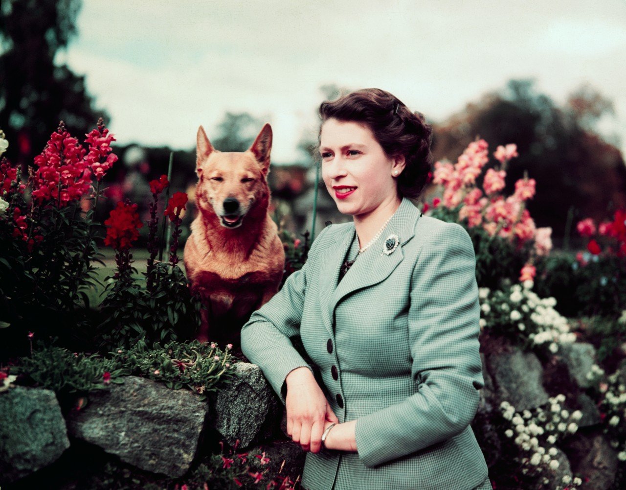 Queen Elizabeth II poses with her dog when she was younger.