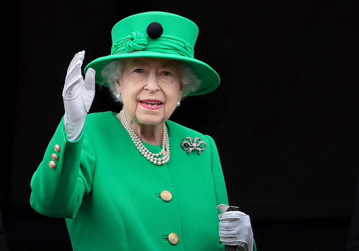Queen Elizabeth, whose funeral is at Westminster Abbey on Sept. 19, 2022, following her Sept. 8 death, waves wearing a green outfit