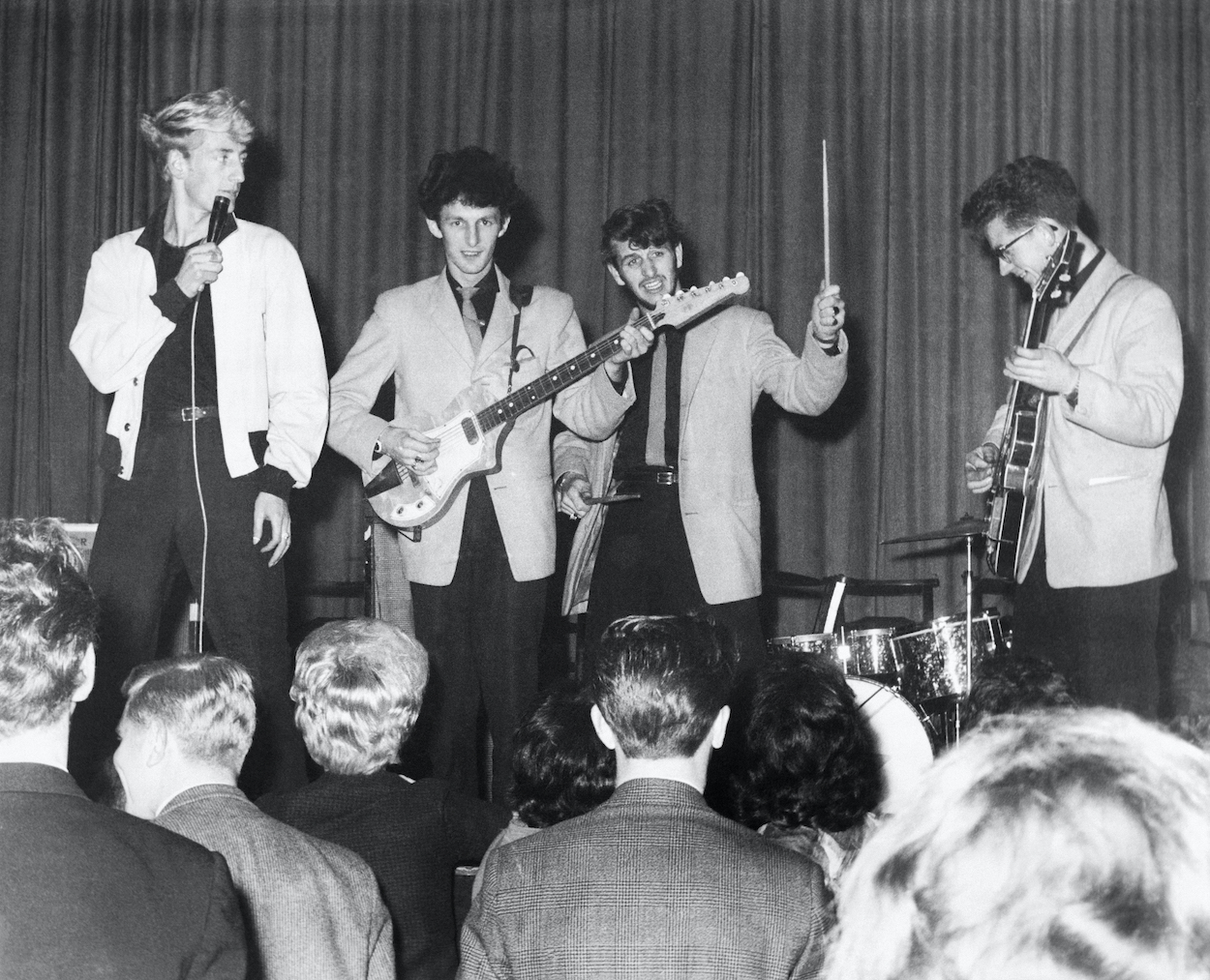 Ringo Starr (second from right) drums during a 1961 concert for Rory Storm and the Hurricanes, Ringo's first successful band that got a German room upgrade thanks to their suits.
