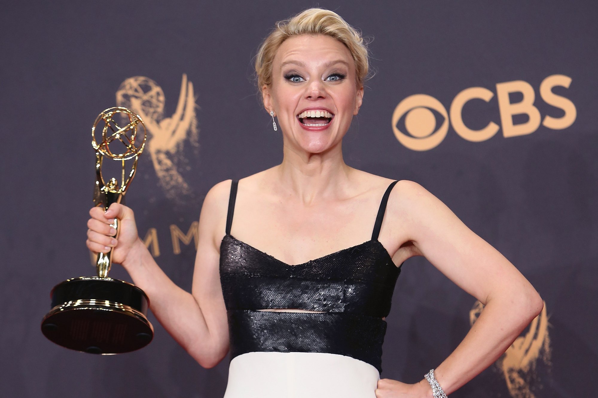 'Saturday Night Live' Kate McKinnon holding an Emmy Award wearing a black top in front of a step and repeat